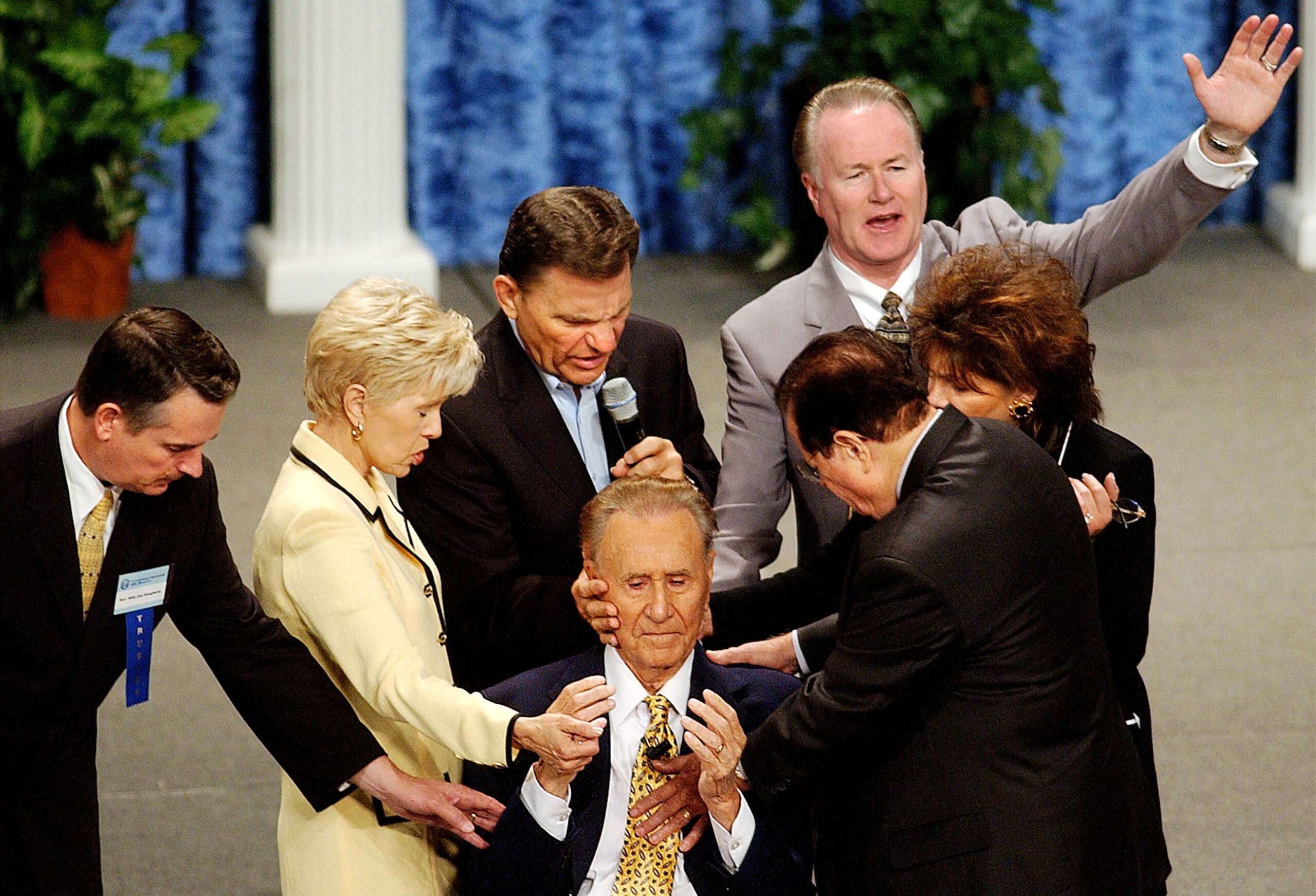 Televangelists lay hands on Oral Roberts, 85, during the International Charismatic Bible Ministries conference in the Mabee Center at Oral Roberts University in Tulsa, Oklahoma, in 2003. From left are, Billy Joe Daugherty; Gloria Copeland; Kenneth Copeland; Charles Green; Richard Roberts; and Lindsay Roberts.