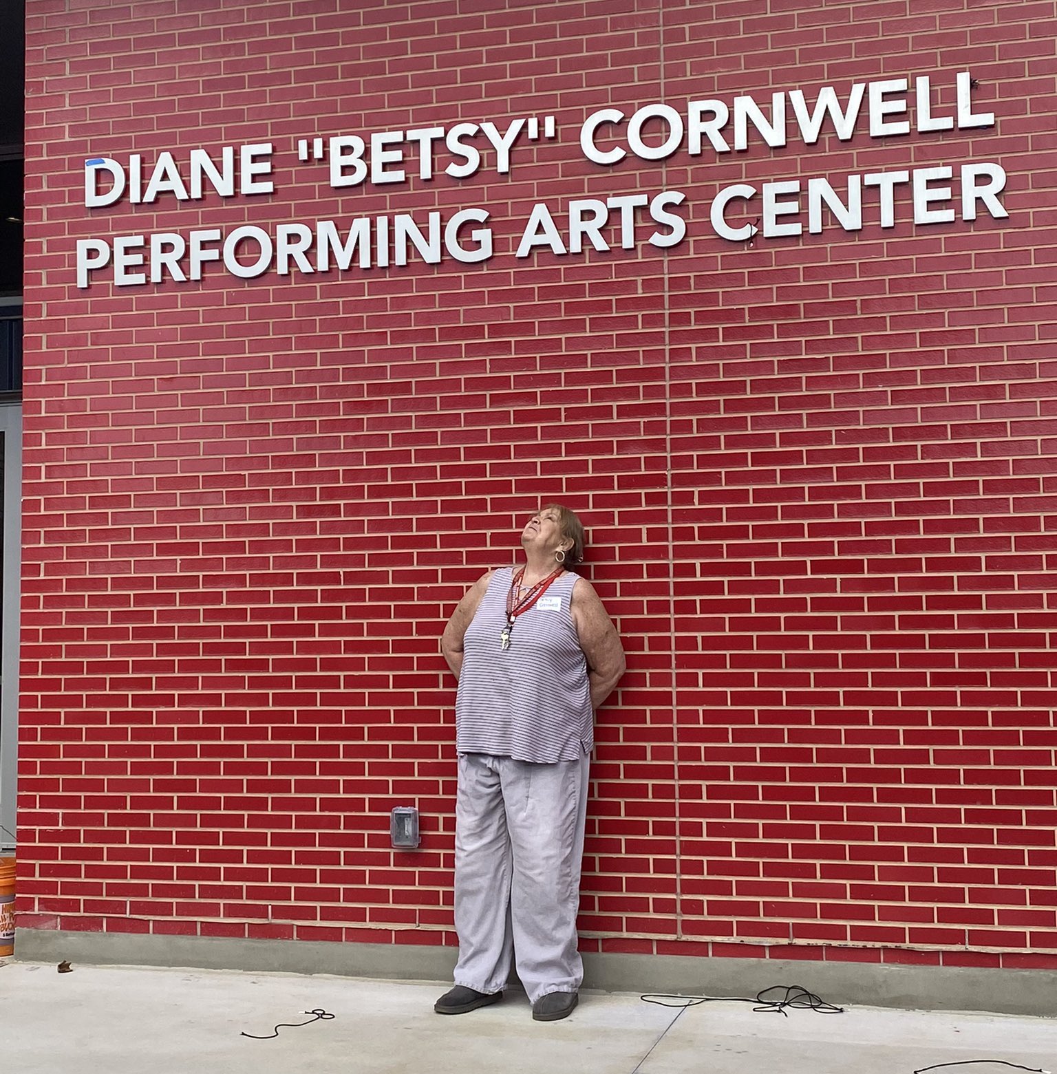 Former AISD theater teacher Diane "Betsy" Cornwell in front of a performing arts center named after her