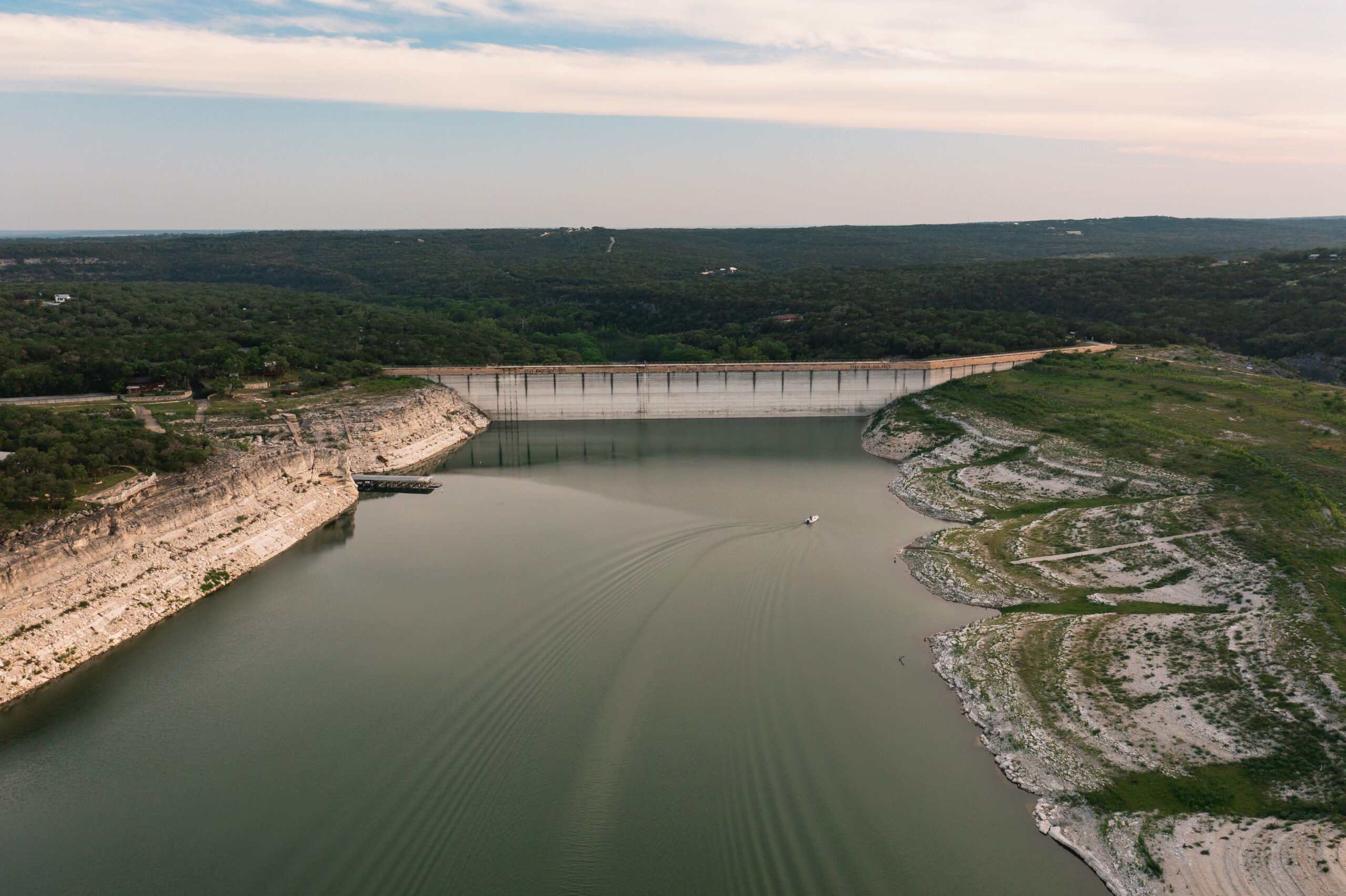 Lines on the Medina Lake dam, as well as on the surrounding shores, show how low the lake is—in May, nearly 83 feet below the conservation pool level.