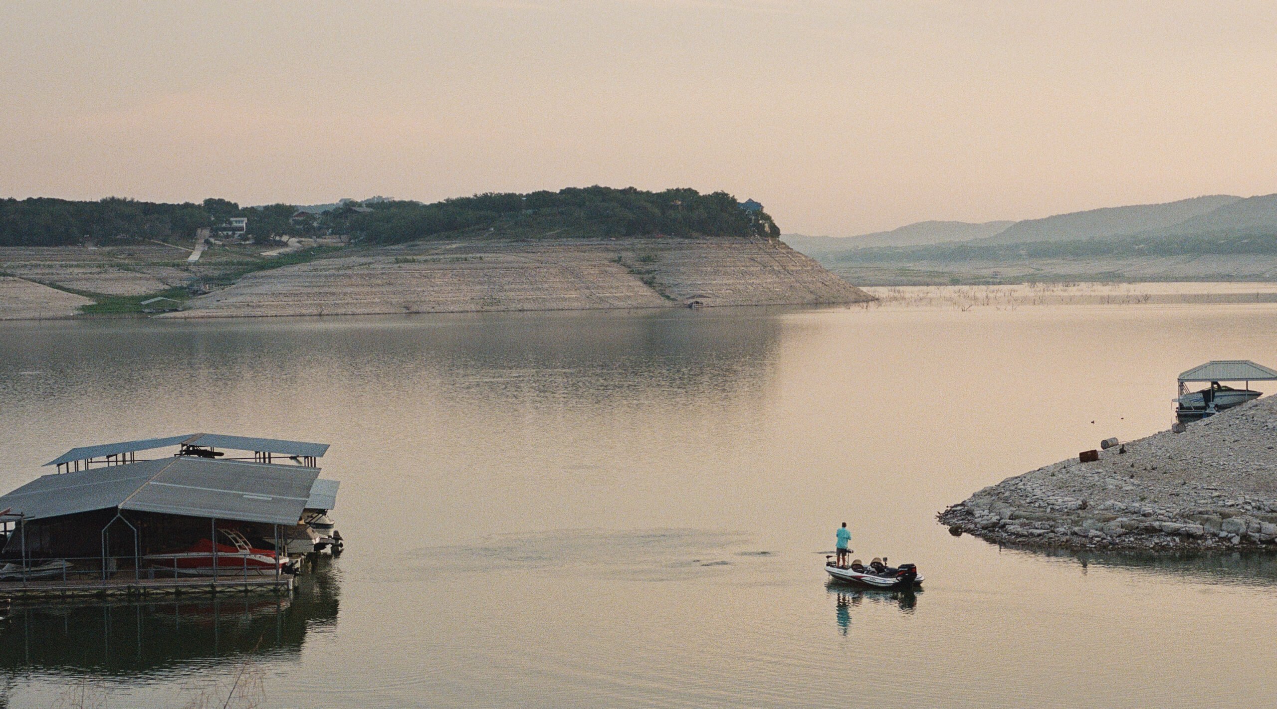 A fisherman reels one in near Red Cove Marina on Medina Lake, where water levels are at 5 percent total capacity.