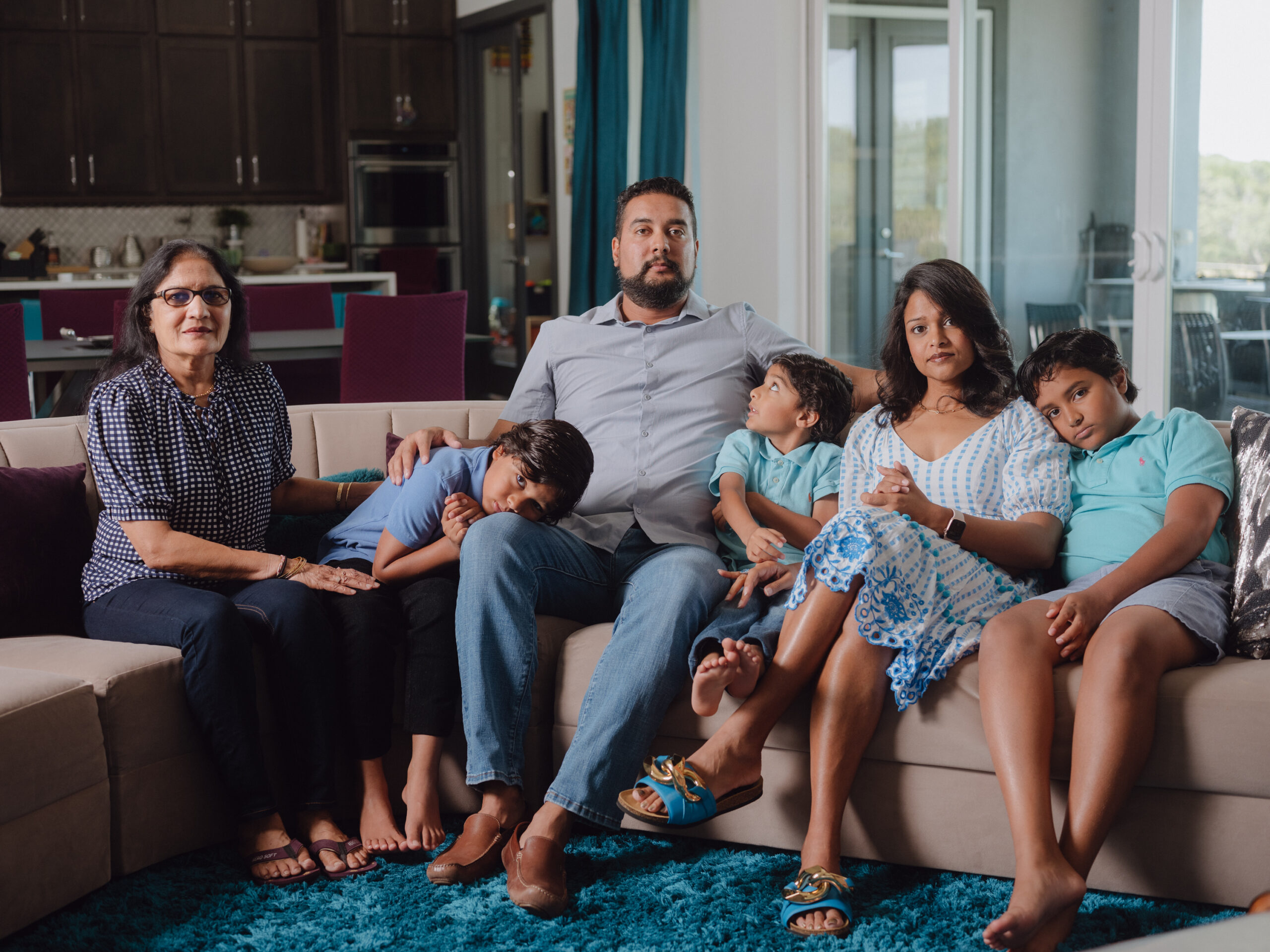 A family portrait, with Mitesh Patel at center, surrounded by his wife and children and mother Mina at far left.