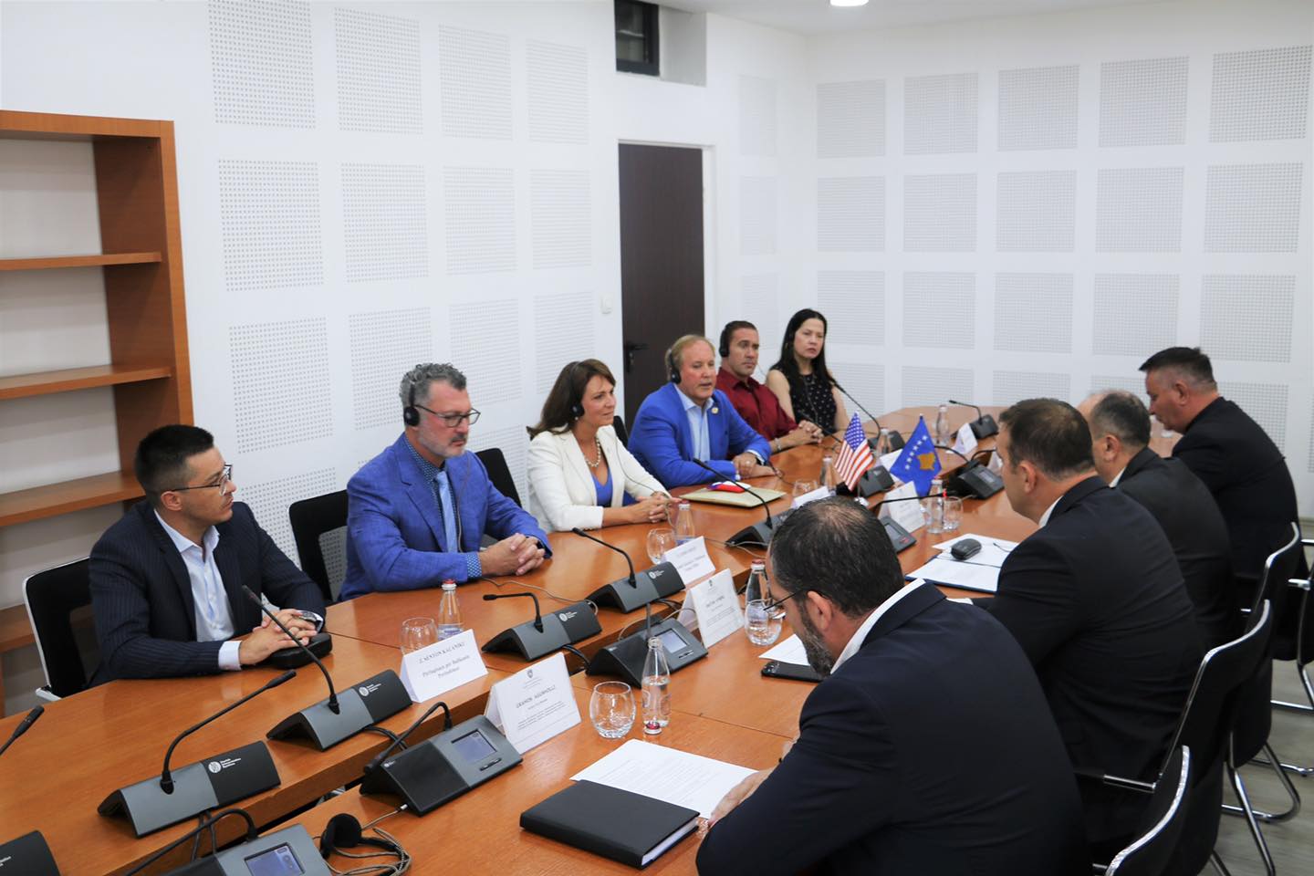 James Frinzi, Angela Paxton, and Ken Paxton sit at a table with representatives of the Kosovo Parliament. 