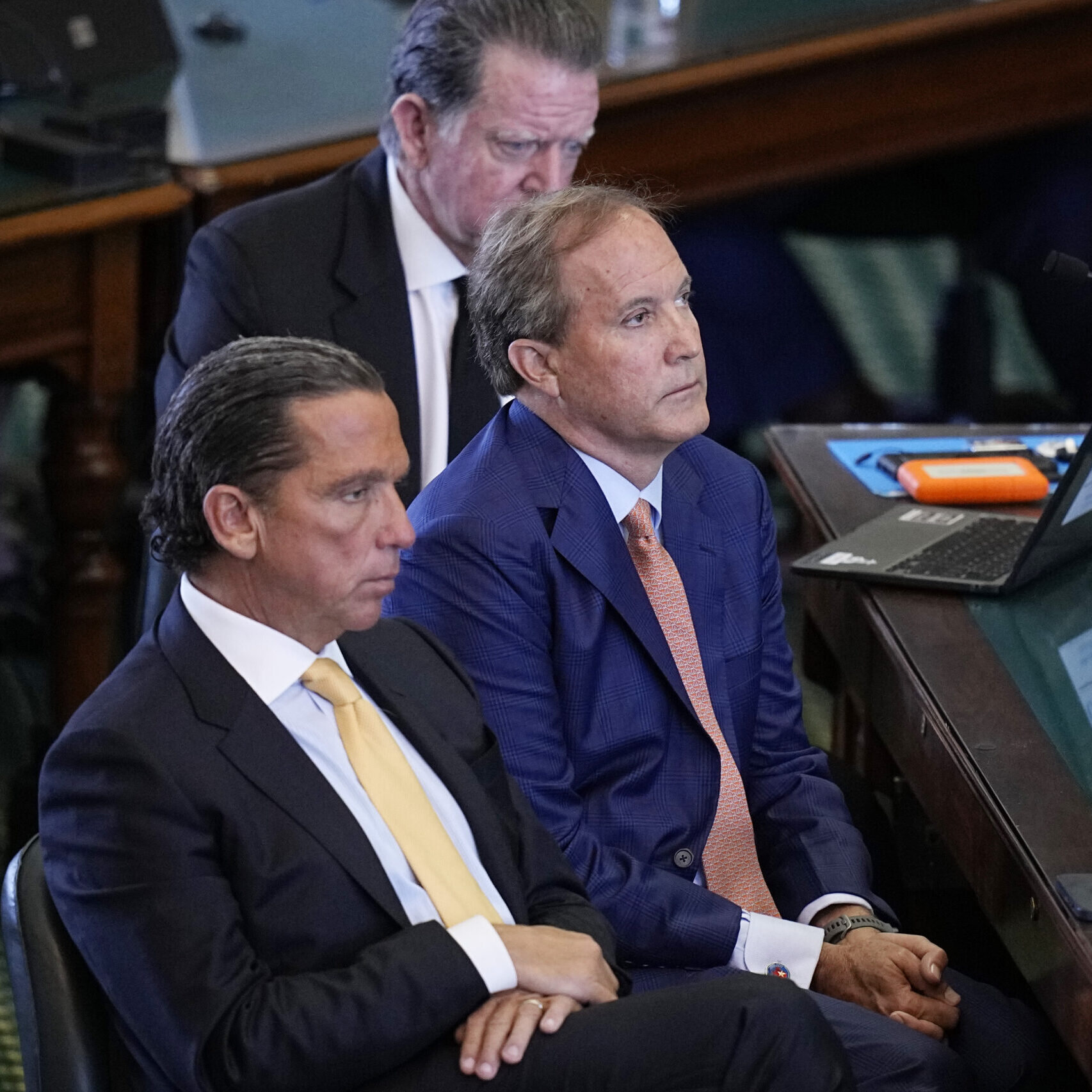 Texas state Attorney General Ken Paxton, center, sits between his attorneys Tony Buzbee, front, and Dan Cogdell, rear, as the articles of his impeachment are read during the his impeachment trial.