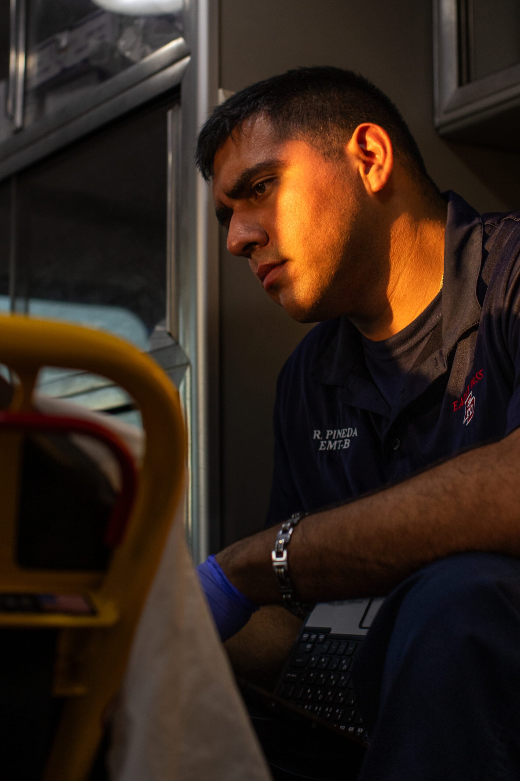 A photo depicting Firefighter EMT Rodrigo Pineda, 30, who asks about an older woman’s medical history as she’s transported to the Fort Duncan Regional Medical Center for swelling in her legs.
