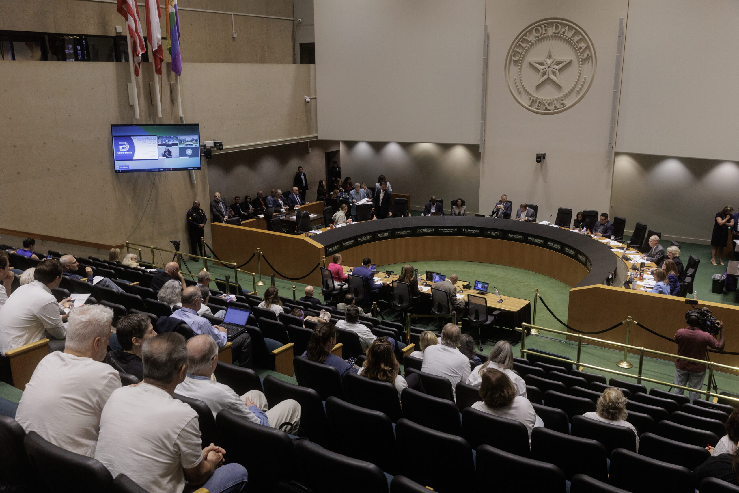 A photo of the medium-sized crowd (several empty seats) watching the Dallas City Council in their chambers.