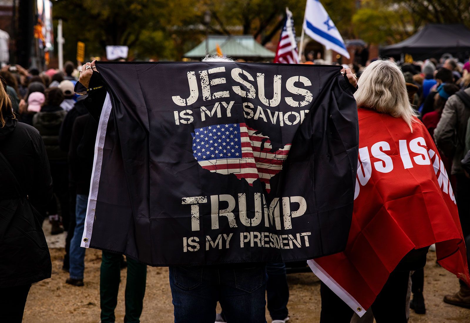 An image of a concert in which an attendee holds up a banner that says, "Jesus is my savior and Trump is my president"