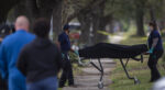 Harris County Institute of Forensic Sciences Medical Examiners carry a body out of a home following a shooting December 30, 2020 in Houston. Four people have been killed at the Houston home in what authorities say was likely a domestic violence shooting that included a man firing at police before turning a gun on himself.