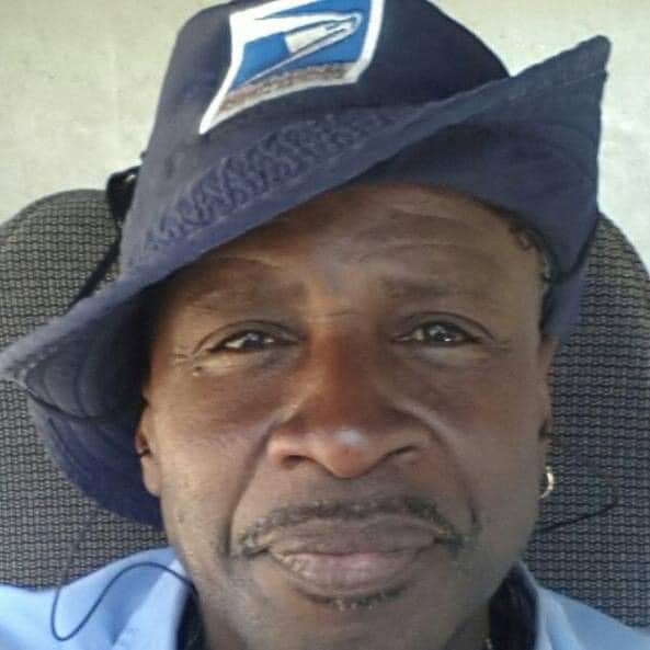 A headshot of Eugene Gates wearing his USPS mail carrier's hat. 