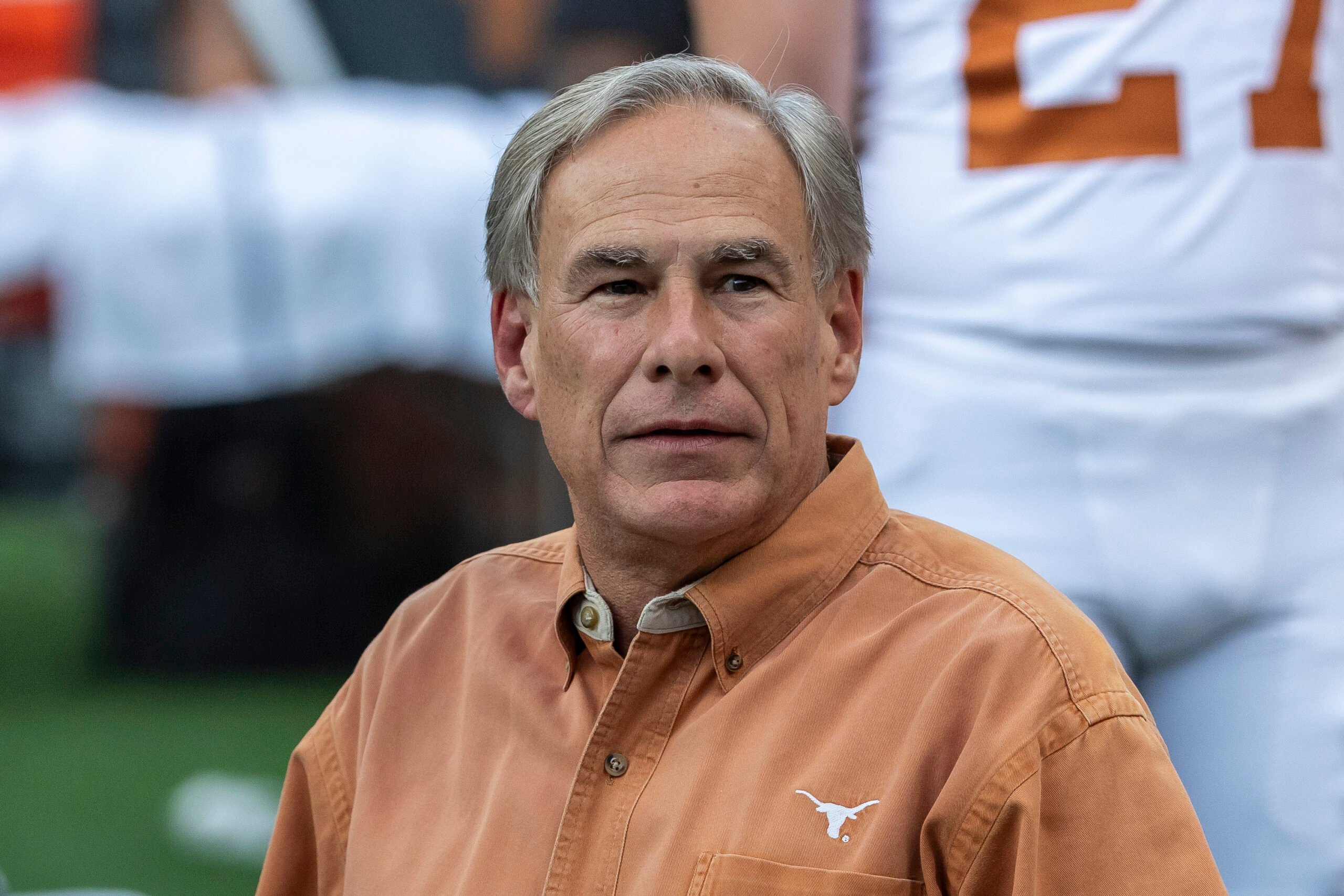 Governor Greg Abbott in an orange button-down with a longhorns logo