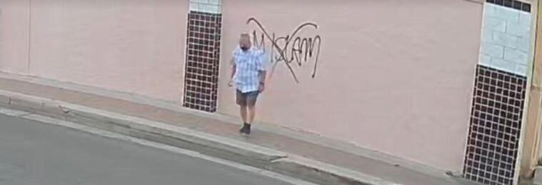 Surveillance footage shows a man in a checkered, light blue shirt spray-painting "No Islam" on an exterior wall with an "X" over it.