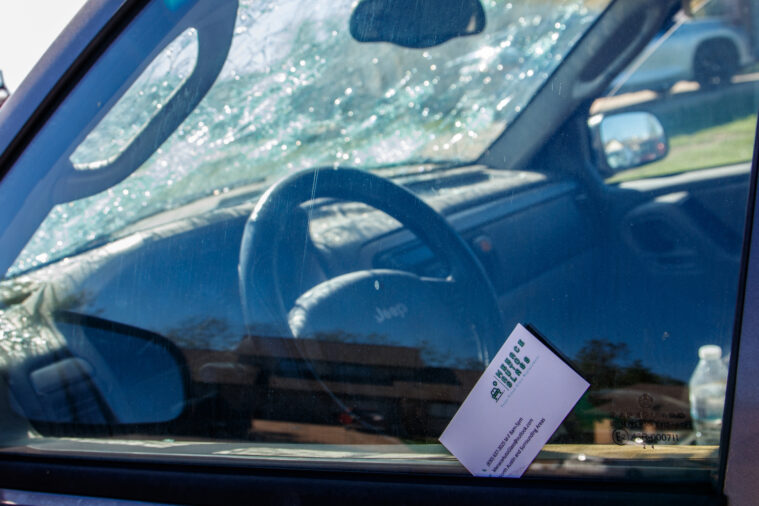 A business card from a local glass repair company to solicit business leans against the windshield of a hail-damaged car in Round Rock on October 16.  After severe weather events, the cost of repairs can escalate, and scammers abound.  Picking a local vendor can protect people needing repairs.