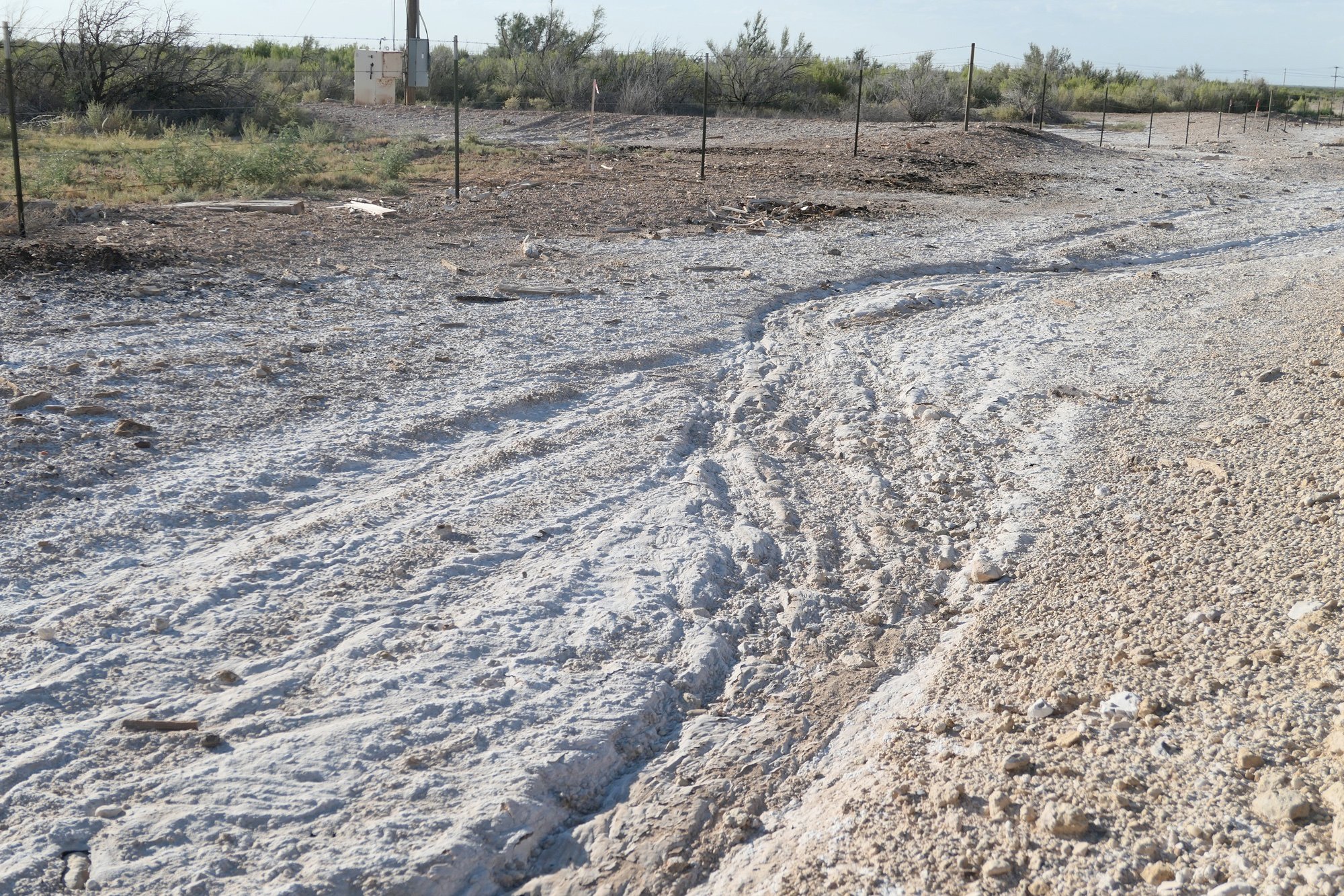 A gray, muddy looking "scar" across the ground forms a river of dead soil across the Texas landscape, clearly showing the path the contamination spill took as it flowed across hundreds of acres.