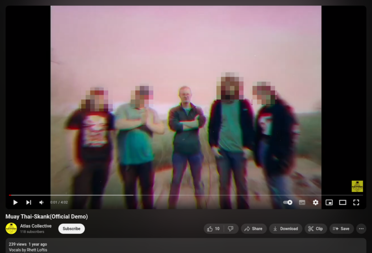 Rhett Murry Loftis, Active Club leader, is seen in a screengrab from a YouTube video, standing at the center of five people with his arms crossed. He is a white man with short hair, wearing blue jeans and a dark shirt.