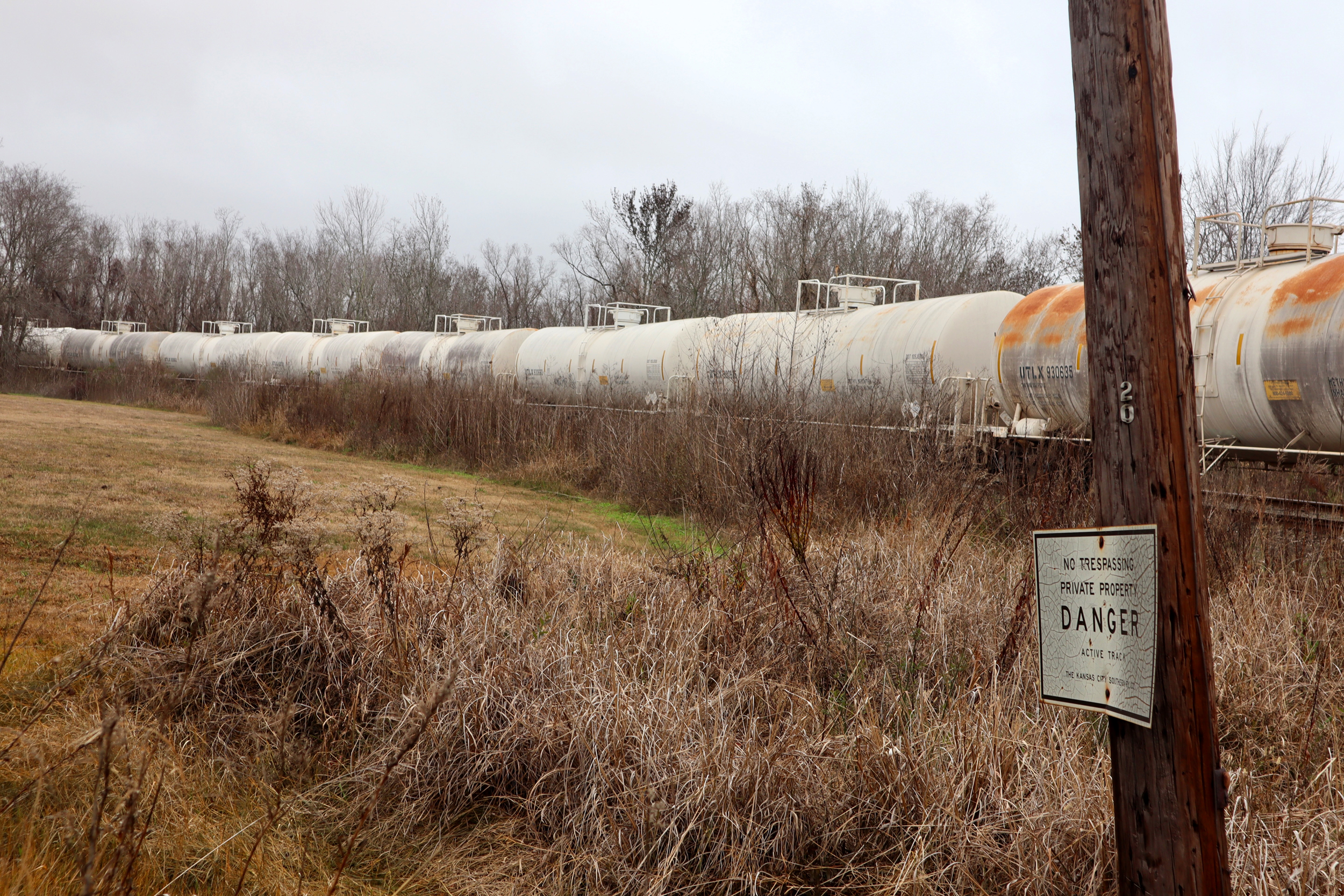 Rail cars from a train parked near an empty field, with a Danger sign prominently displayed.